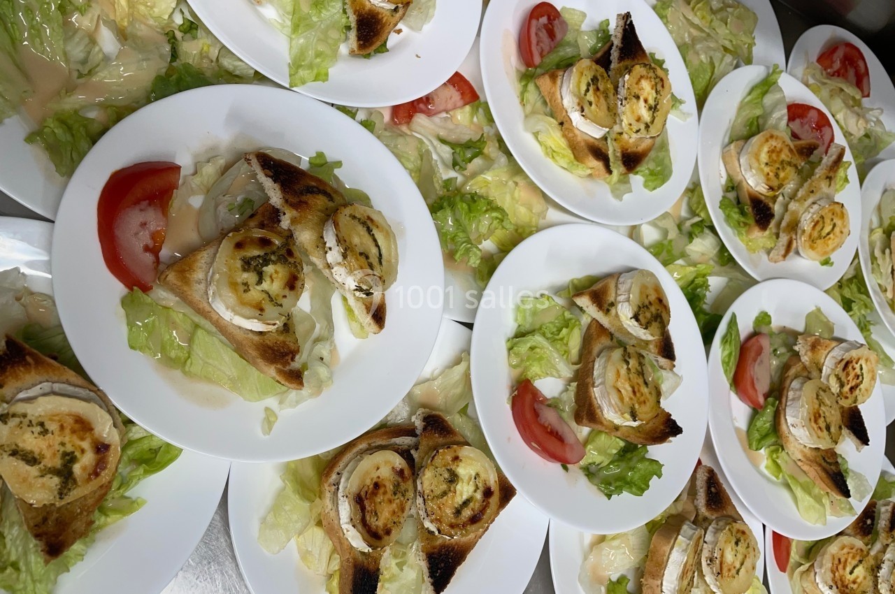 Assiettes de salade garnies de toasts au fromage de chèvre gratiné, tranches de tomate et feuilles de laitue.