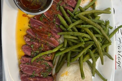 Miniature Location salle Le Blanc-Mesnil (Seine-Saint-Denis) - L'Horloge #27 Assiette contenant un steak grillé, une purée de pommes de terre, une salade verte et une sauce servie dans un ramequin.