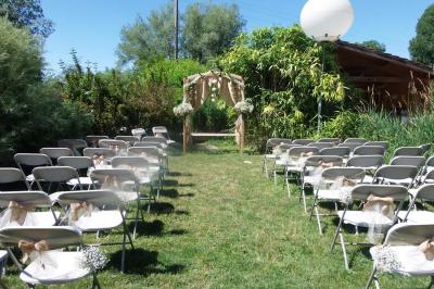 Miniature Location salle Ornacieux (Isère) - Domaine du Moulin Piongo #4 Chambre lumineuse avec lits en bois, bureau, armoire, décorations végétales et vue sur un jardin par la fenêtre.