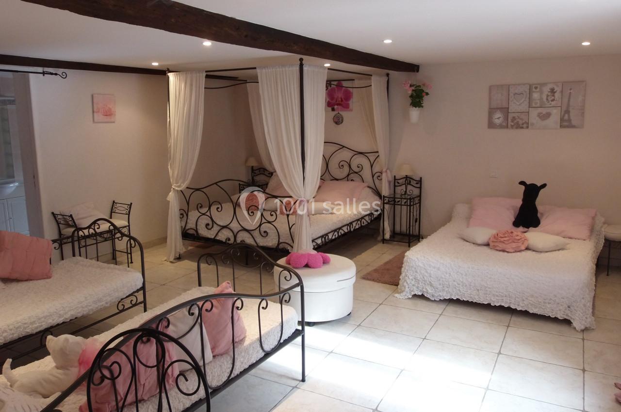 Location salle Ornacieux (Isère) - Domaine du Moulin Piongo #27 Chambre lumineuse avec lits à baldaquin, décorée dans des tons roses et blancs, poutres apparentes au plafond.