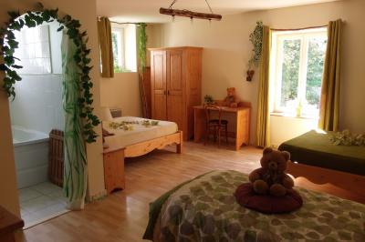 Miniature Location salle Ornacieux (Isère) - Domaine du Moulin Piongo #29 Chambre lumineuse avec lits en bois, bureau, armoire, décorations végétales et vue sur un jardin par la fenêtre.