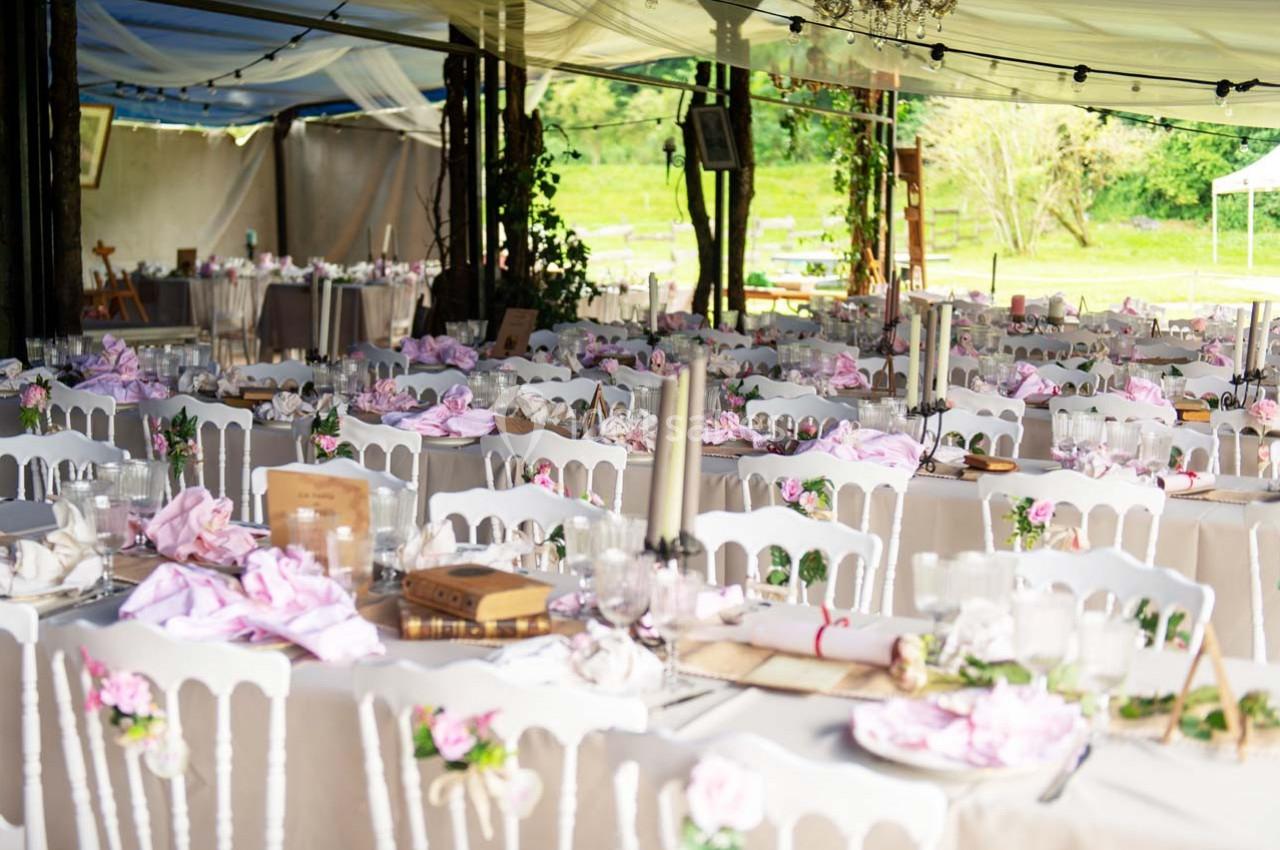 Location salle Ornacieux (Isère) - Domaine du Moulin Piongo #6 Salle de réception en plein air décorée avec des tables nappées, des chaises blanches et des détails floraux roses.