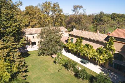 Miniature Location salle Miramas (Bouches-du-Rhône) - La Bambouseraie de Sulauze #2 Chambre lumineuse avec lit double, commode en bois, portant à vêtements, télévision et poutre apparente au plafond.