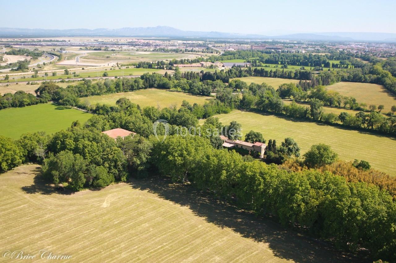 Vue aérienne d'une campagne verdoyante avec des champs, des arbres et des bâtiments, en arrière-plan une ville et des…
