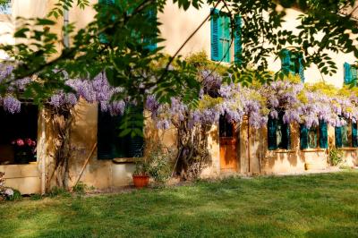 Miniature Location salle Miramas (Bouches-du-Rhône) - La Bambouseraie de Sulauze #10 Chambre lumineuse avec lit double, commode en bois, portant à vêtements, télévision et poutre apparente au plafond.
