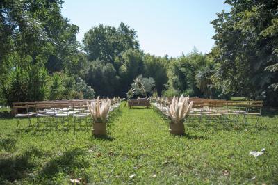 Miniature Location salle Miramas (Bouches-du-Rhône) - La Bambouseraie de Sulauze #3 Chambre lumineuse avec lit double, commode en bois, portant à vêtements, télévision et poutre apparente au plafond.