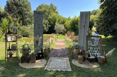 Miniature Location salle Miramas (Bouches-du-Rhône) - La Bambouseraie de Sulauze #5 Chambre lumineuse avec lit double, commode en bois, portant à vêtements, télévision et poutre apparente au plafond.