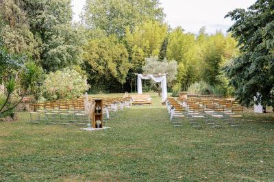 Miniature Location salle Miramas (Bouches-du-Rhône) - La Bambouseraie de Sulauze #4 Chambre lumineuse avec lit double, commode en bois, portant à vêtements, télévision et poutre apparente au plafond.