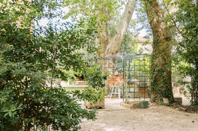 Miniature Location salle Miramas (Bouches-du-Rhône) - La Bambouseraie de Sulauze #56 Chambre lumineuse avec lit double, commode en bois, portant à vêtements, télévision et poutre apparente au plafond.