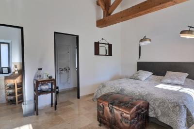 Miniature Location salle Miramas (Bouches-du-Rhône) - La Bambouseraie de Sulauze #100 Chambre lumineuse avec lit double, commode en bois, portant à vêtements, télévision et poutre apparente au plafond.