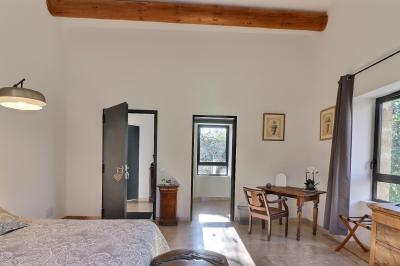 Miniature Location salle Miramas (Bouches-du-Rhône) - La Bambouseraie de Sulauze #102 Chambre lumineuse avec lit double, commode en bois, portant à vêtements, télévision et poutre apparente au plafond.