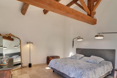Miniature Location salle Miramas (Bouches-du-Rhône) - La Bambouseraie de Sulauze #105 Chambre lumineuse avec lit double, commode en bois, portant à vêtements, télévision et poutre apparente au plafond.