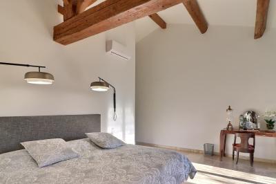 Miniature Location salle Miramas (Bouches-du-Rhône) - La Bambouseraie de Sulauze #110 Chambre lumineuse avec lit double, commode en bois, portant à vêtements, télévision et poutre apparente au plafond.