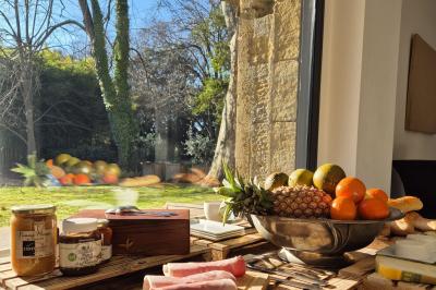 Miniature Location salle Miramas (Bouches-du-Rhône) - La Bambouseraie de Sulauze #112 Chambre lumineuse avec lit double, commode en bois, portant à vêtements, télévision et poutre apparente au plafond.