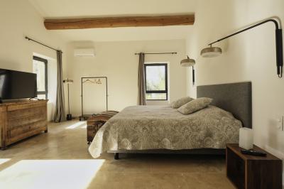 Miniature Location salle Miramas (Bouches-du-Rhône) - La Bambouseraie de Sulauze #118 Chambre lumineuse avec lit double, commode en bois, portant à vêtements, télévision et poutre apparente au plafond.