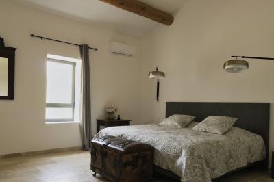 Miniature Location salle Miramas (Bouches-du-Rhône) - La Bambouseraie de Sulauze #124 Chambre lumineuse avec lit double, commode en bois, portant à vêtements, télévision et poutre apparente au plafond.
