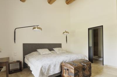 Miniature Location salle Miramas (Bouches-du-Rhône) - La Bambouseraie de Sulauze #128 Chambre lumineuse avec lit double, commode en bois, portant à vêtements, télévision et poutre apparente au plafond.