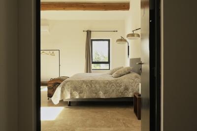 Miniature Location salle Miramas (Bouches-du-Rhône) - La Bambouseraie de Sulauze #131 Chambre lumineuse avec lit double, commode en bois, portant à vêtements, télévision et poutre apparente au plafond.