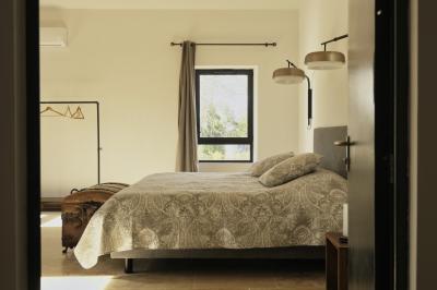 Miniature Location salle Miramas (Bouches-du-Rhône) - La Bambouseraie de Sulauze #132 Chambre lumineuse avec lit double, commode en bois, portant à vêtements, télévision et poutre apparente au plafond.