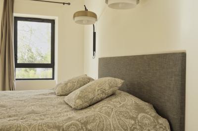 Miniature Location salle Miramas (Bouches-du-Rhône) - La Bambouseraie de Sulauze #134 Chambre lumineuse avec lit double, commode en bois, portant à vêtements, télévision et poutre apparente au plafond.