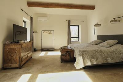 Miniature Location salle Miramas (Bouches-du-Rhône) - La Bambouseraie de Sulauze #135 Chambre lumineuse avec lit double, commode en bois, portant à vêtements, télévision et poutre apparente au plafond.