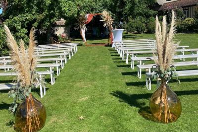 Miniature Location salle Beaubray (Eure) - Auberge de la Comtesse #1 Décoration de salle avec échelle en bois ornée de lettres ’LOVE’, pampas et vases, éclairage violet en arrière-plan.