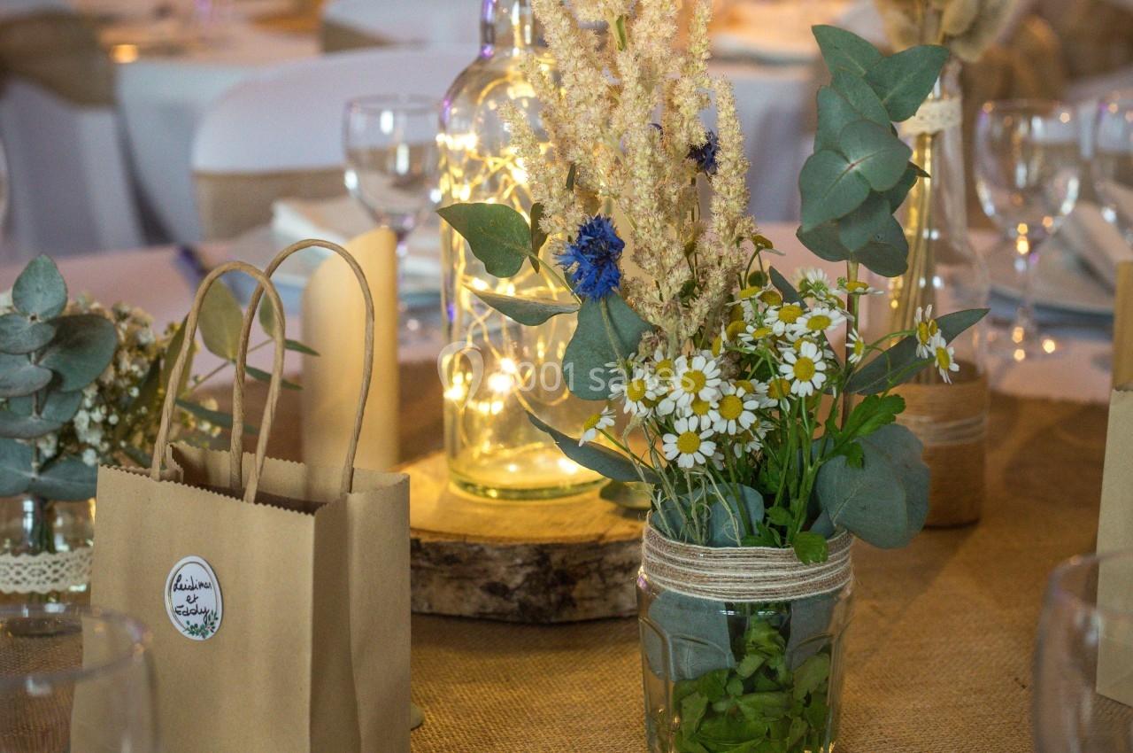 Location salle Beaubray (Eure) - Auberge de la Comtesse #9 Centre de table avec fleurs séchées, marguerites et feuillage dans des bocaux en verre, décoré de guirlandes lumineuses.