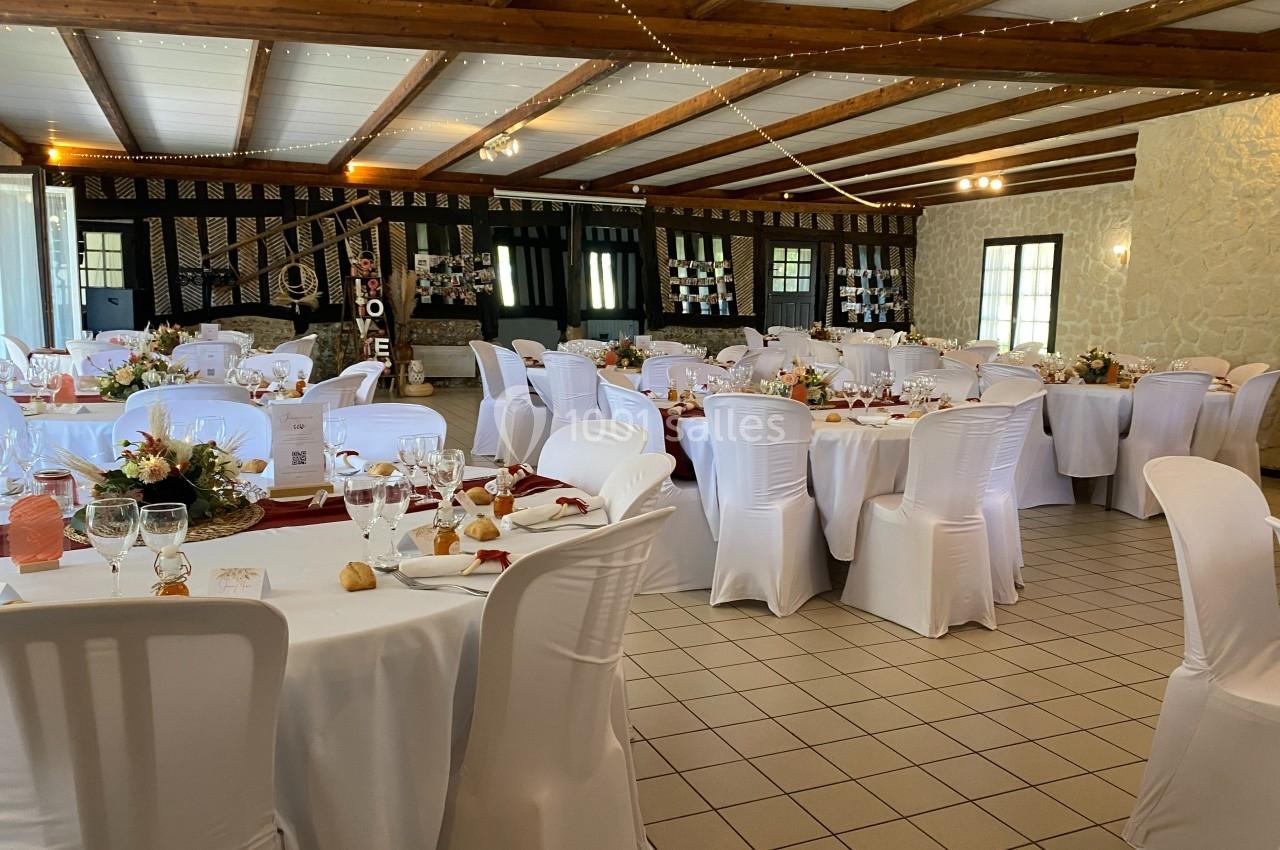 Location salle Beaubray (Eure) - Auberge de la Comtesse #8 Salle de réception décorée avec des tables rondes, nappes blanches, chaises houssées et arrangements floraux.