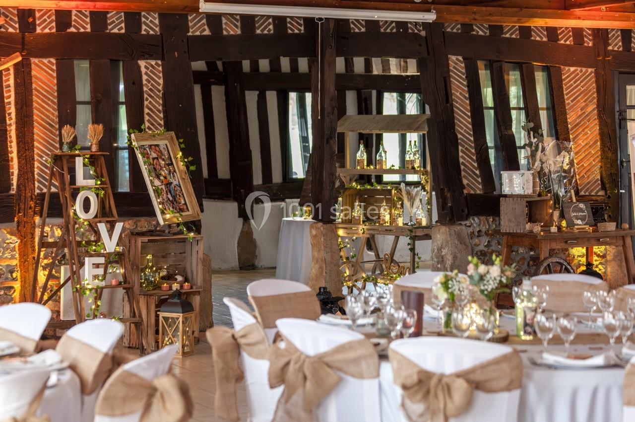 Location salle Beaubray (Eure) - Auberge de la Comtesse #2 Salle de réception décorée pour un mariage, avec tables dressées, chaises ornées et éléments rustiques en bois.