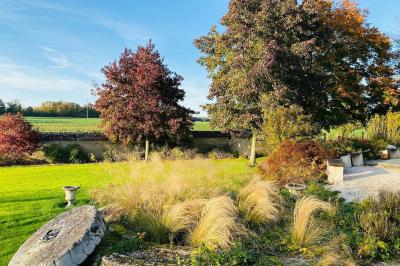 Miniature Mariage d'Automne - Auberge de la comtesse Décoration de salle avec échelle en bois ornée de lettres ’LOVE’, pampas et vases, éclairage violet en arrière-plan.