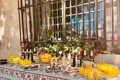 Grande salle vide avec un sol en pierre, plafond en bois avec poutres apparentes et lustres suspendus, décorée de plantes.