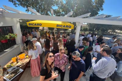 Grande salle vide avec un sol en pierre, plafond en bois avec poutres apparentes et lustres suspendus, décorée de plantes.