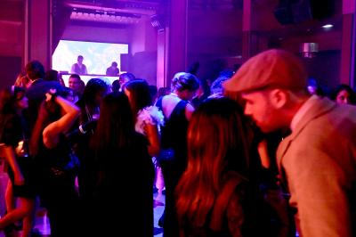 Miniature DJ Vincennes (Val-de-Marne) - Frank Merry #5 Personnes dansant et discutant dans une ambiance tamisée de boîte de nuit avec un écran lumineux en arrière-plan.