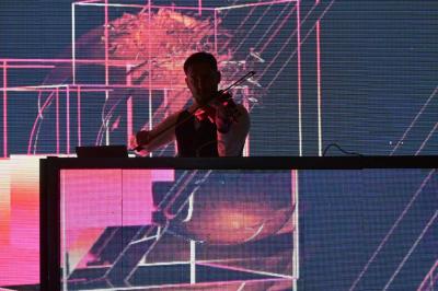 Miniature DJ Vincennes (Val-de-Marne) - Frank Merry #2 Personnes dansant et discutant dans une ambiance tamisée de boîte de nuit avec un écran lumineux en arrière-plan.