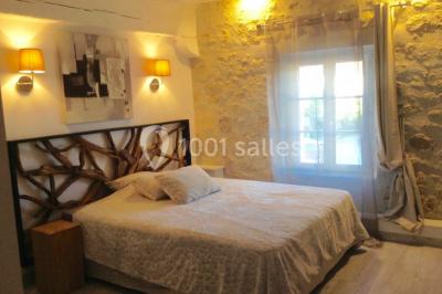 Chambre avec lit double, douche accessible, sol en parquet clair et éclairage moderne.