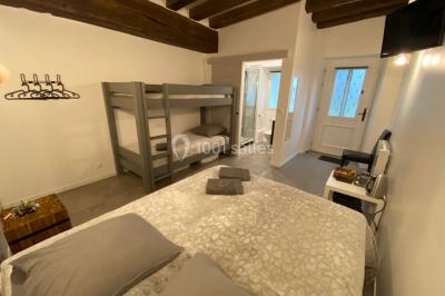 Chambre avec lit double, douche accessible, sol en parquet clair et éclairage moderne.