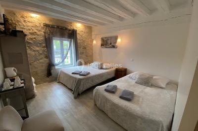 Chambre avec lit double, douche accessible, sol en parquet clair et éclairage moderne.