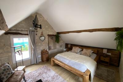 Chambre avec lit double, douche accessible, sol en parquet clair et éclairage moderne.