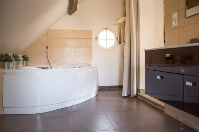 Chambre avec lit double, douche accessible, sol en parquet clair et éclairage moderne.