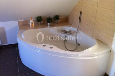 Chambre avec lit double, douche accessible, sol en parquet clair et éclairage moderne.