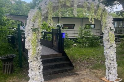 Miniature Location salle Jouy-le-Moutier (Val-d'Oise) - Le Yacht #51 Un parc verdoyant avec des arbres feuillus et une allée ensoleillée menant à un bâtiment blanc au loin.