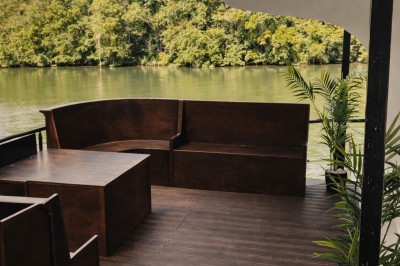 Table élégamment dressée avec nappes blanches, serviettes pliées, verres et décorations florales dans une salle lumineuse.