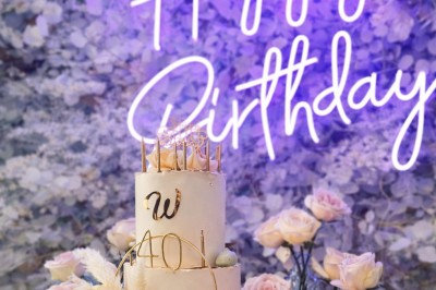 Table élégamment dressée avec nappes blanches, serviettes pliées, verres et décorations florales dans une salle lumineuse.