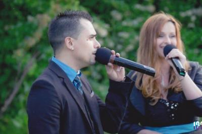 Un couple danse dans une salle faiblement éclairée avec des lumières colorées et une ambiance festive.