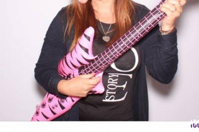 Un couple danse dans une salle faiblement éclairée avec des lumières colorées et une ambiance festive.