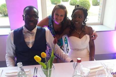 Un couple danse dans une salle faiblement éclairée avec des lumières colorées et une ambiance festive.