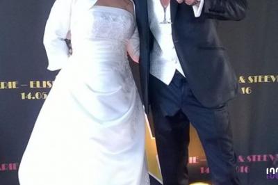 Un couple danse dans une salle faiblement éclairée avec des lumières colorées et une ambiance festive.