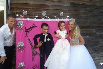 Un couple danse dans une salle faiblement éclairée avec des lumières colorées et une ambiance festive.