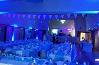 Un couple danse dans une salle faiblement éclairée avec des lumières colorées et une ambiance festive.