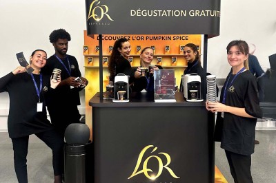 Miniature MHBA - Mon Hôte-sse Bien Aimé-e #2 Quatre femmes en robe noire sourient debout sur une terrasse en bois avec un fond de verdure.